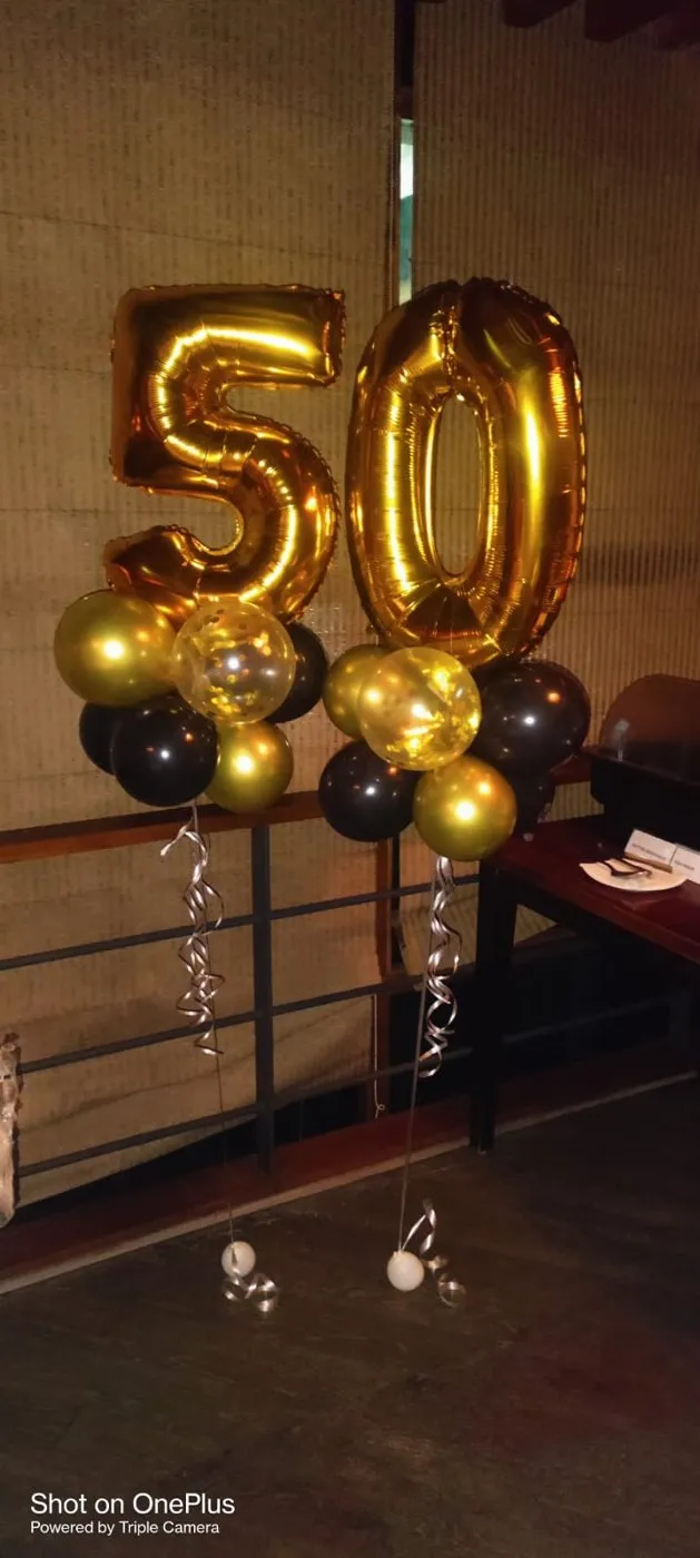 Gold number balloons with black balloon clusters
